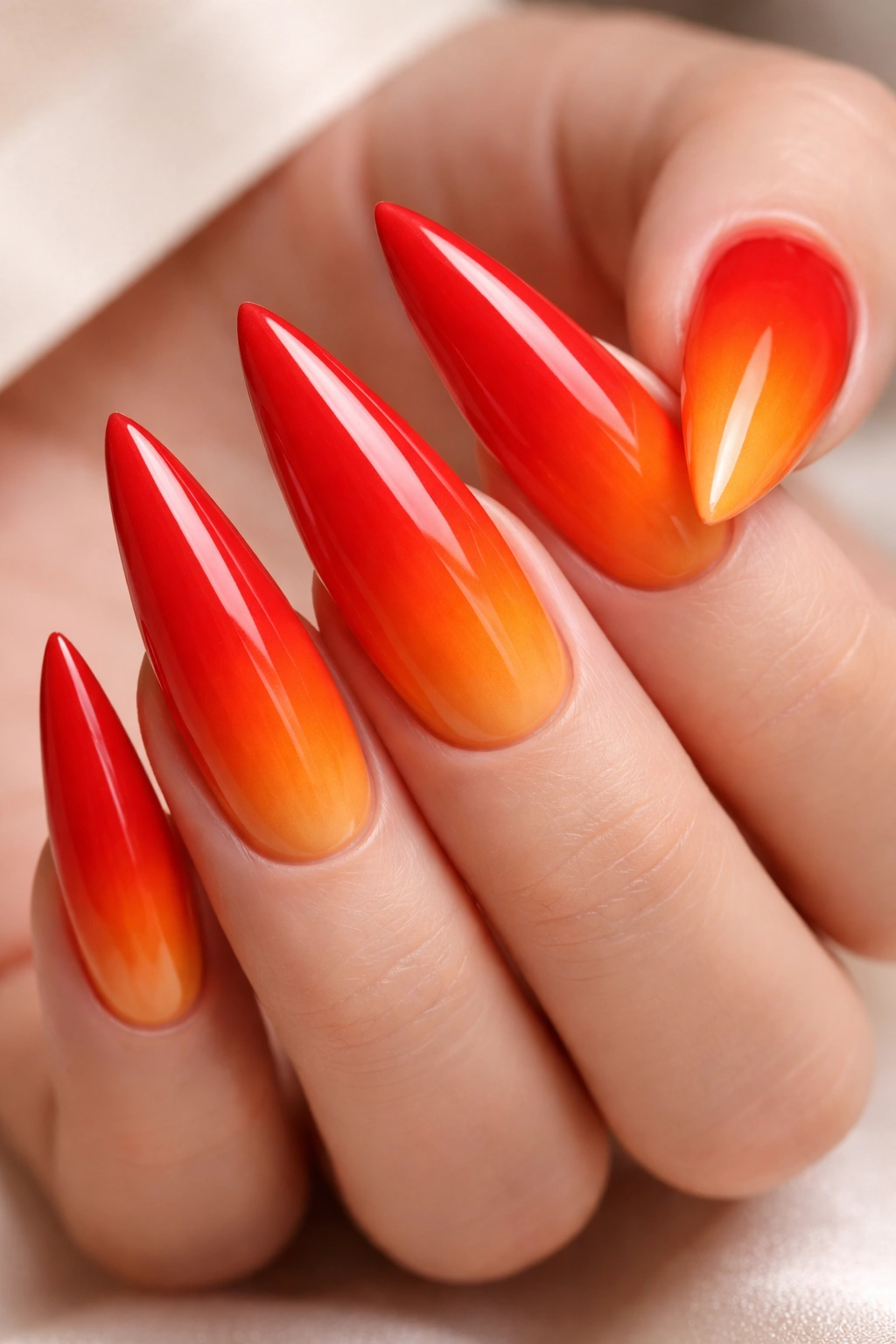 Close-up red to orange ombre stiletto nails