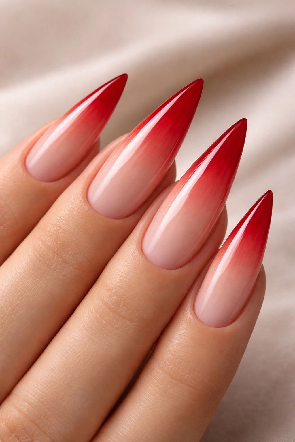 Red stiletto nail with reverse ombre to nude at tip