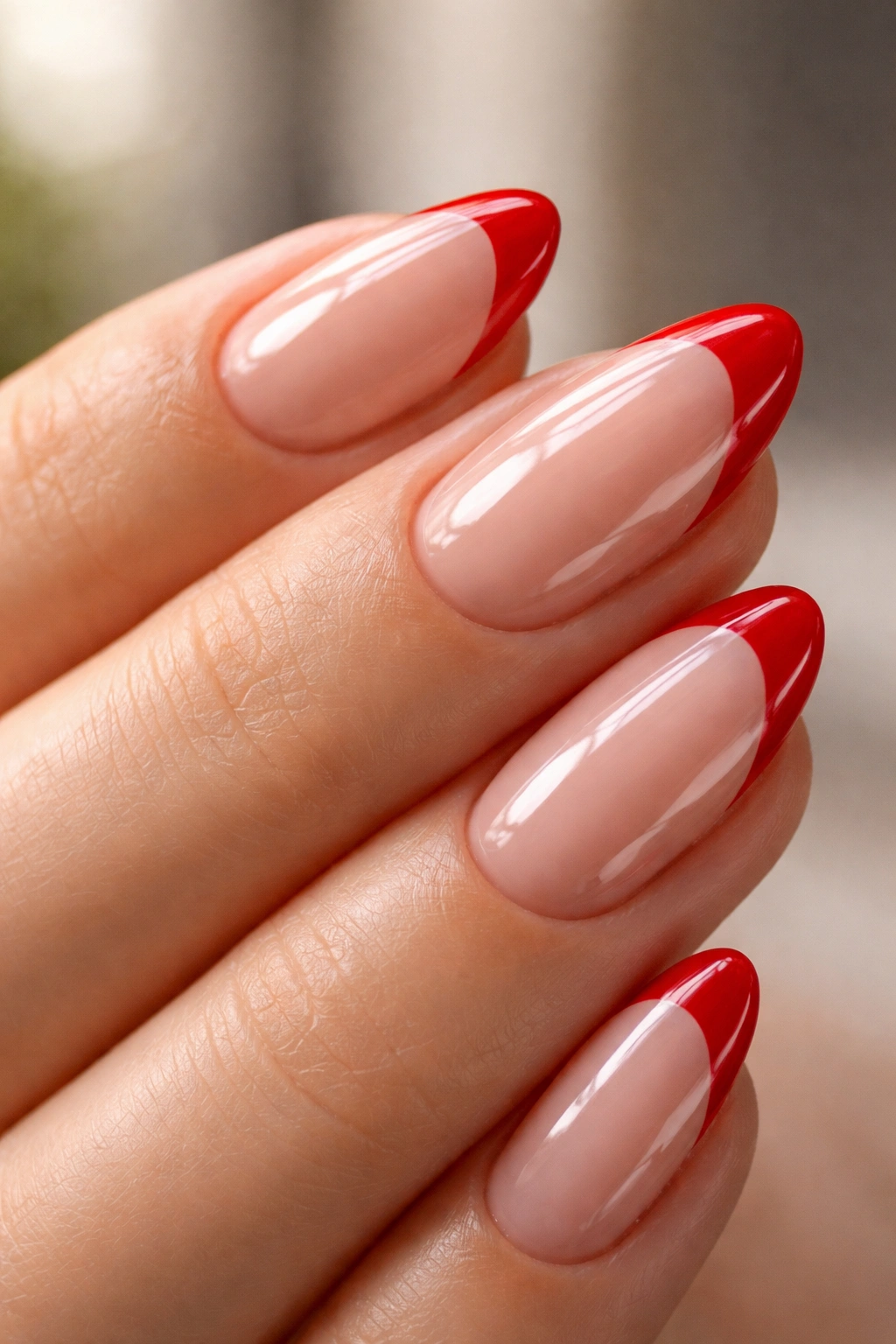 Close-up of hand with red tips showing edge-capped tips and glossy top coat