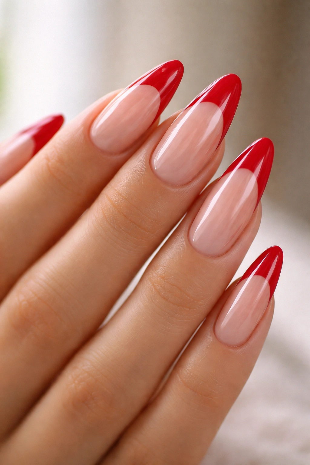 Almond nails with red tips on clear base showing negative space