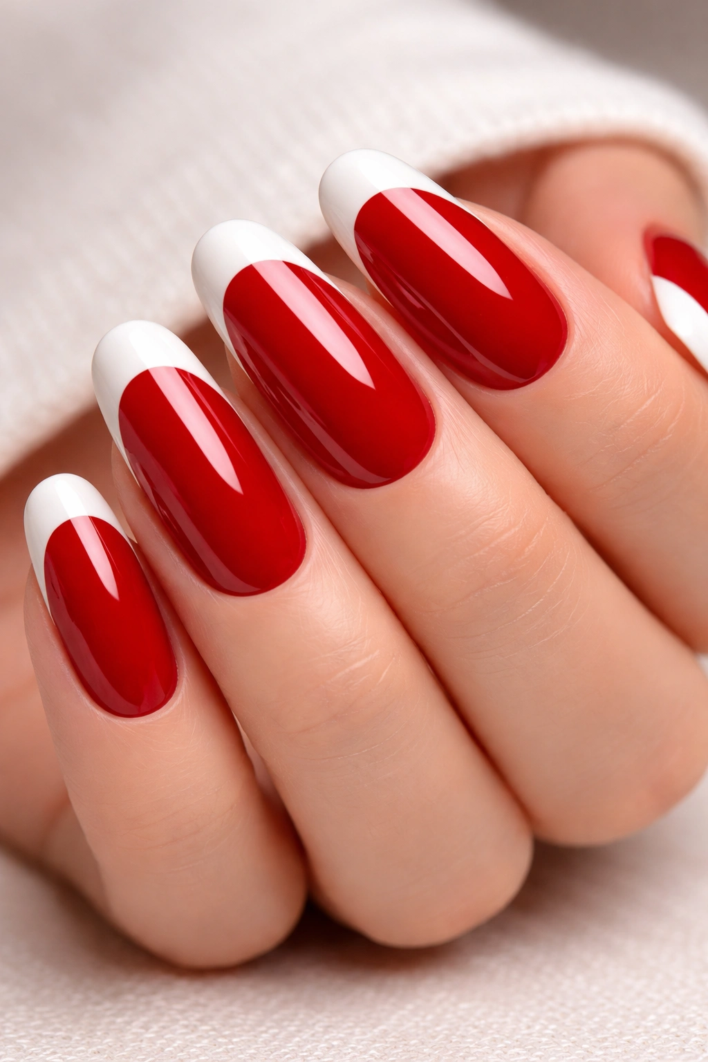 Close-up of long round red nails with white French tips