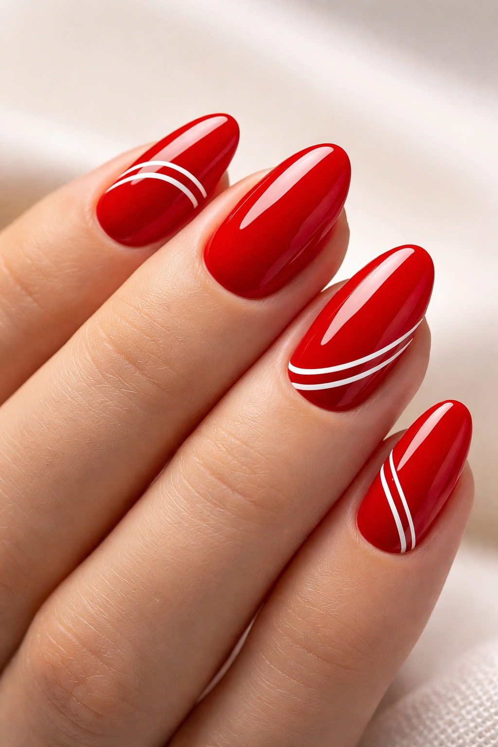 Red nails with white minimalist line art on almond shape