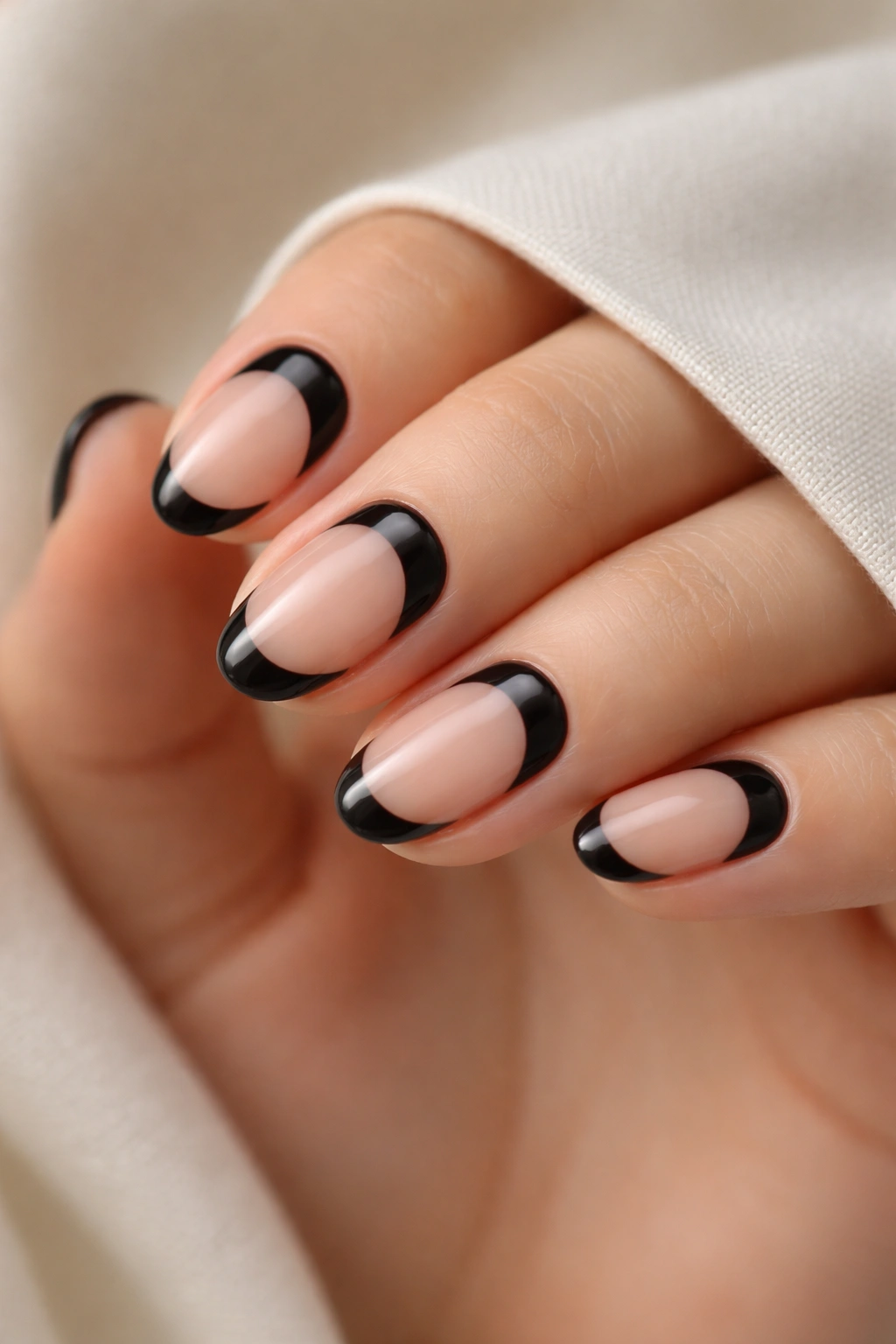 Close-up of short oval nails with reverse black tips near the cuticle