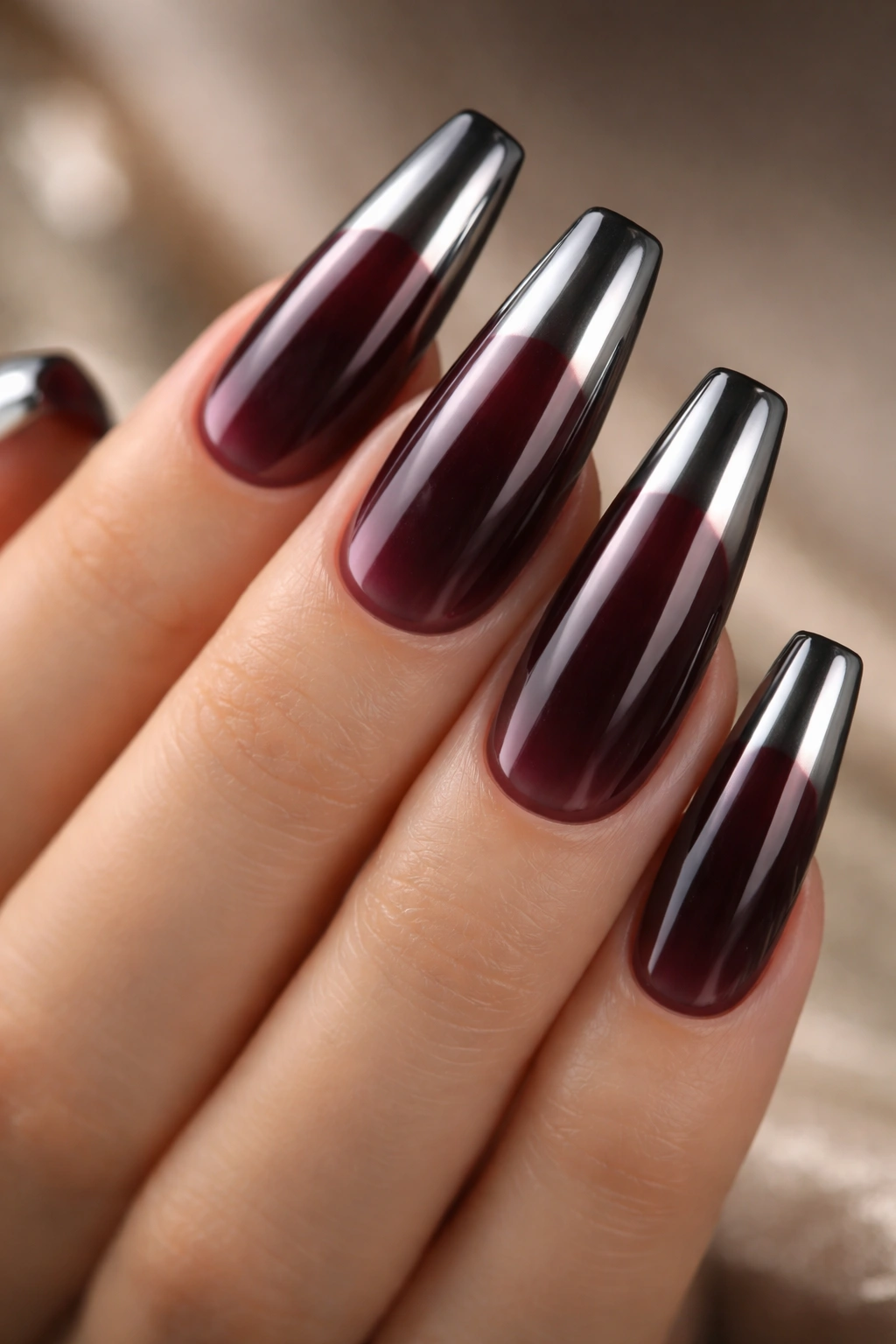 Reverse chrome ombre coffin nails with burgundy base fading to chrome tips, macro shot