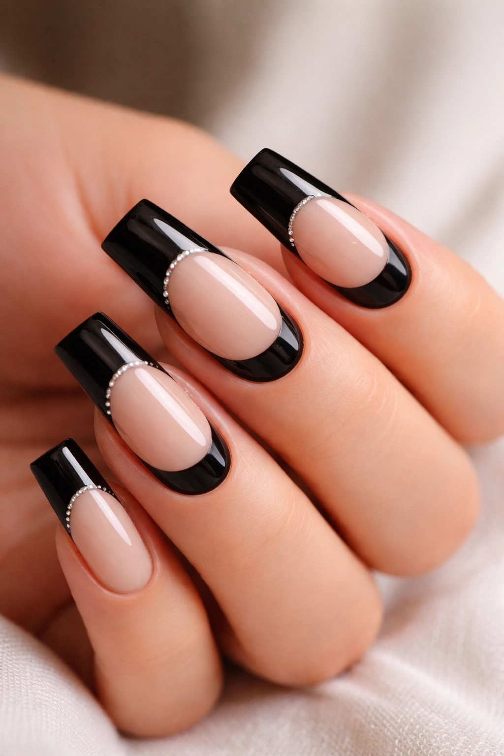 Close-up of duck-shaped nails with black reverse design at the cuticle