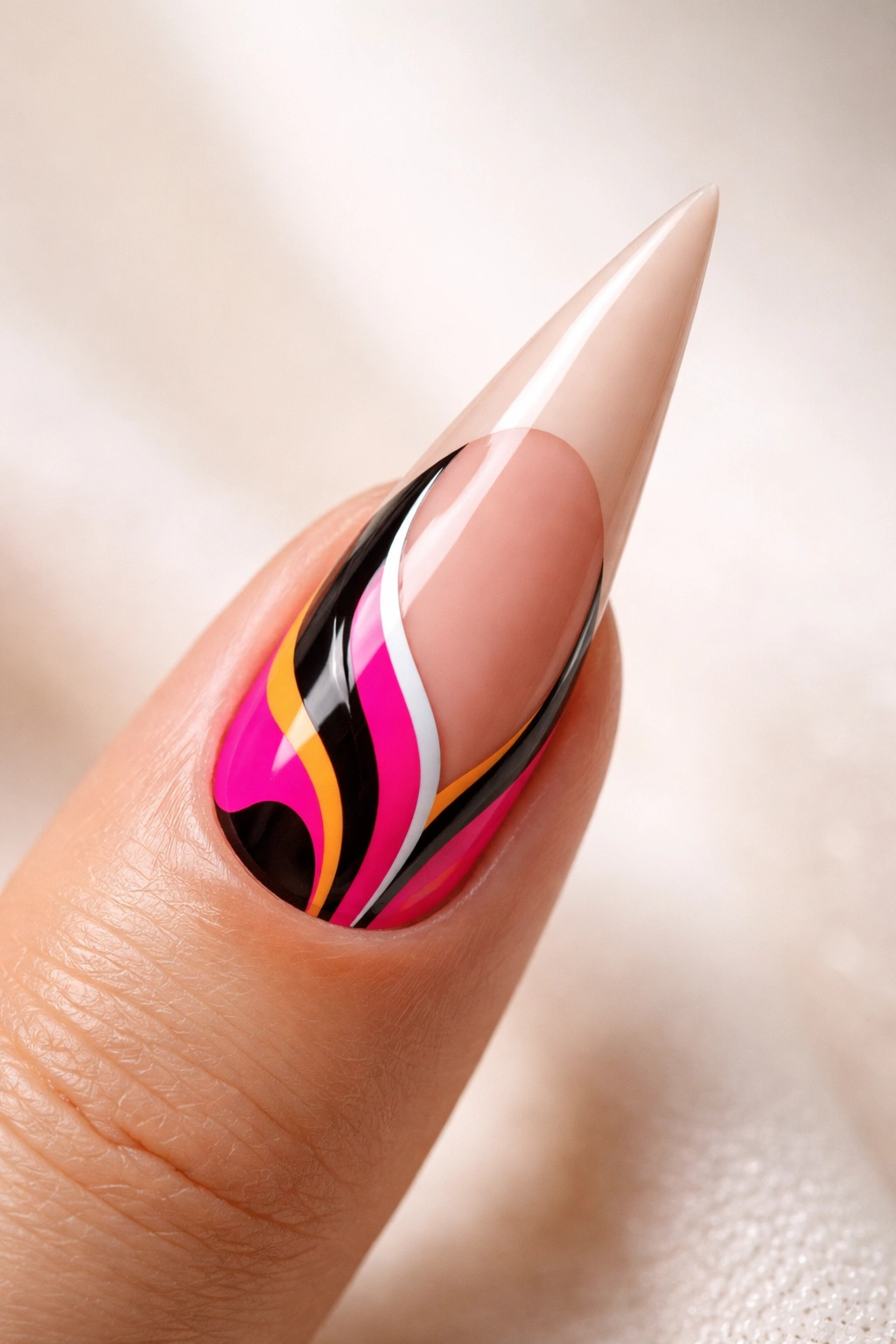 Stiletto nail with lower half in bold graphic pattern and a clean tip