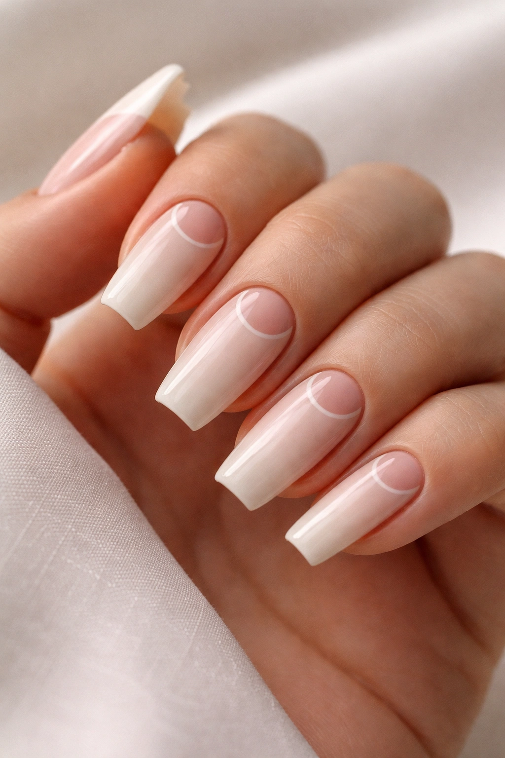 Close-up of reverse French tips on medium coffin nails with base color at the cuticle and natural tip