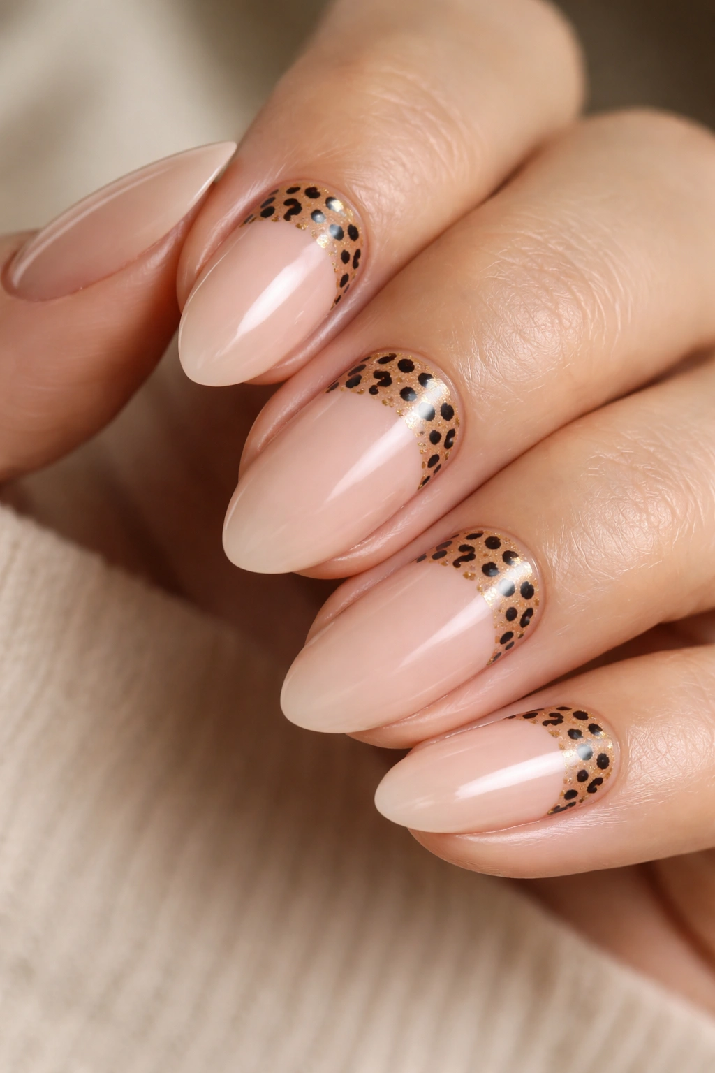 Close-up of short almond nails with leopard spots near the cuticle