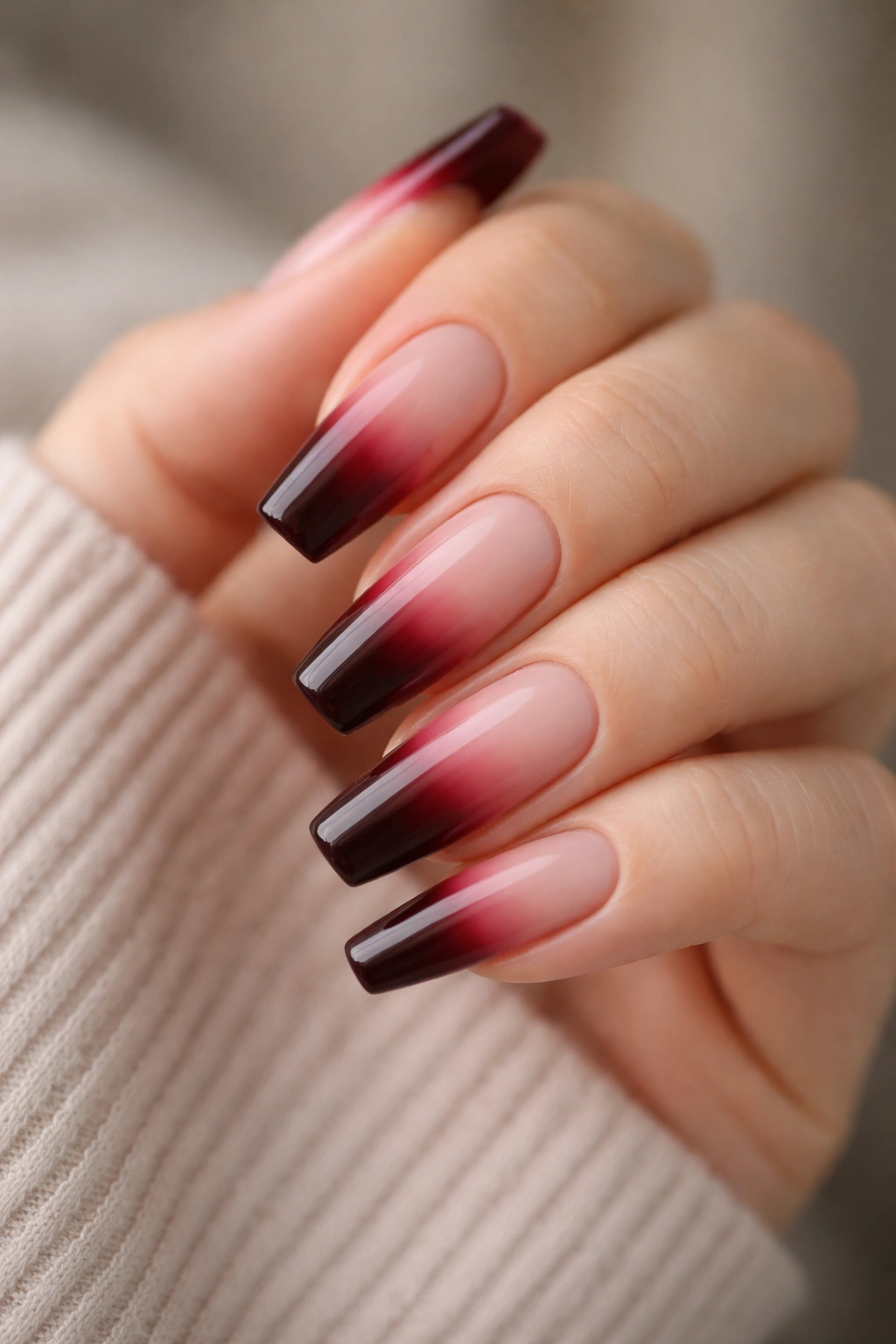 Close-up of nails with pale-to-dark burgundy reverse ombre at tips