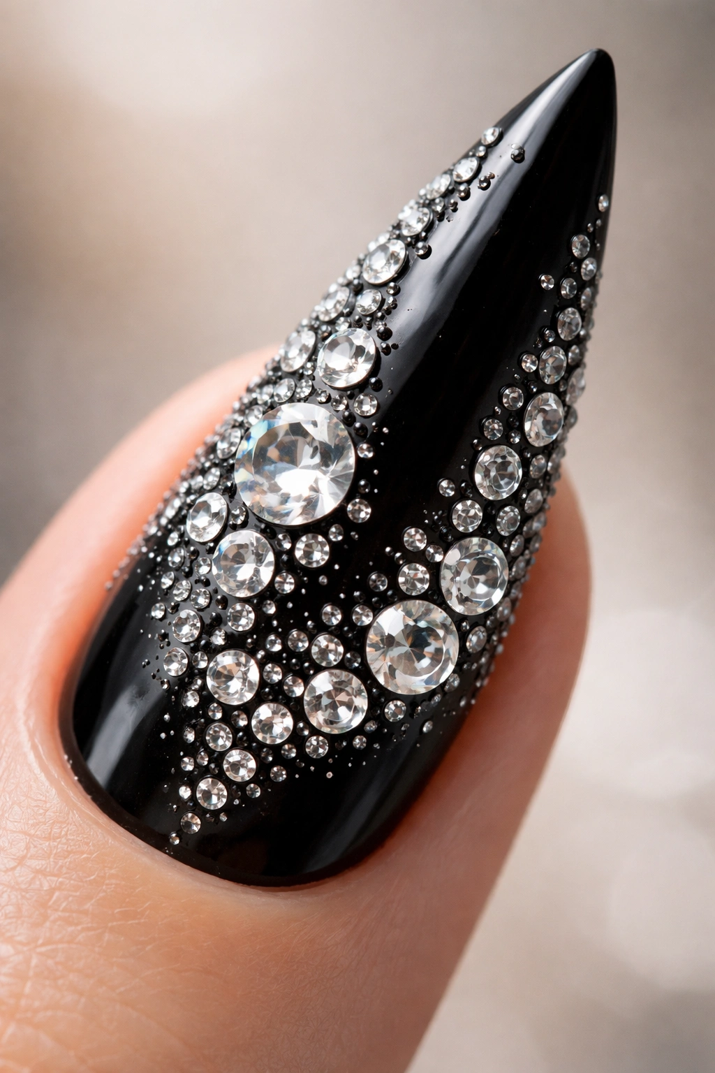Black stiletto nail with mixed rhinestone sizes for dimension