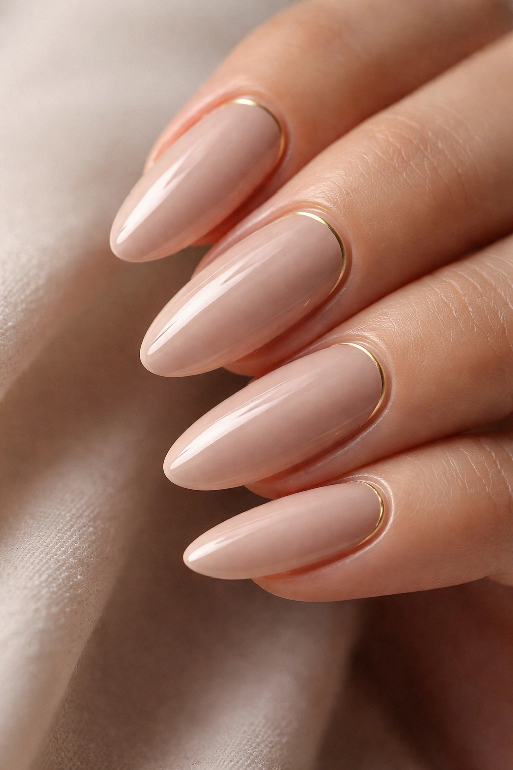 Rose beige nails with thin gold accent on tapered ovals