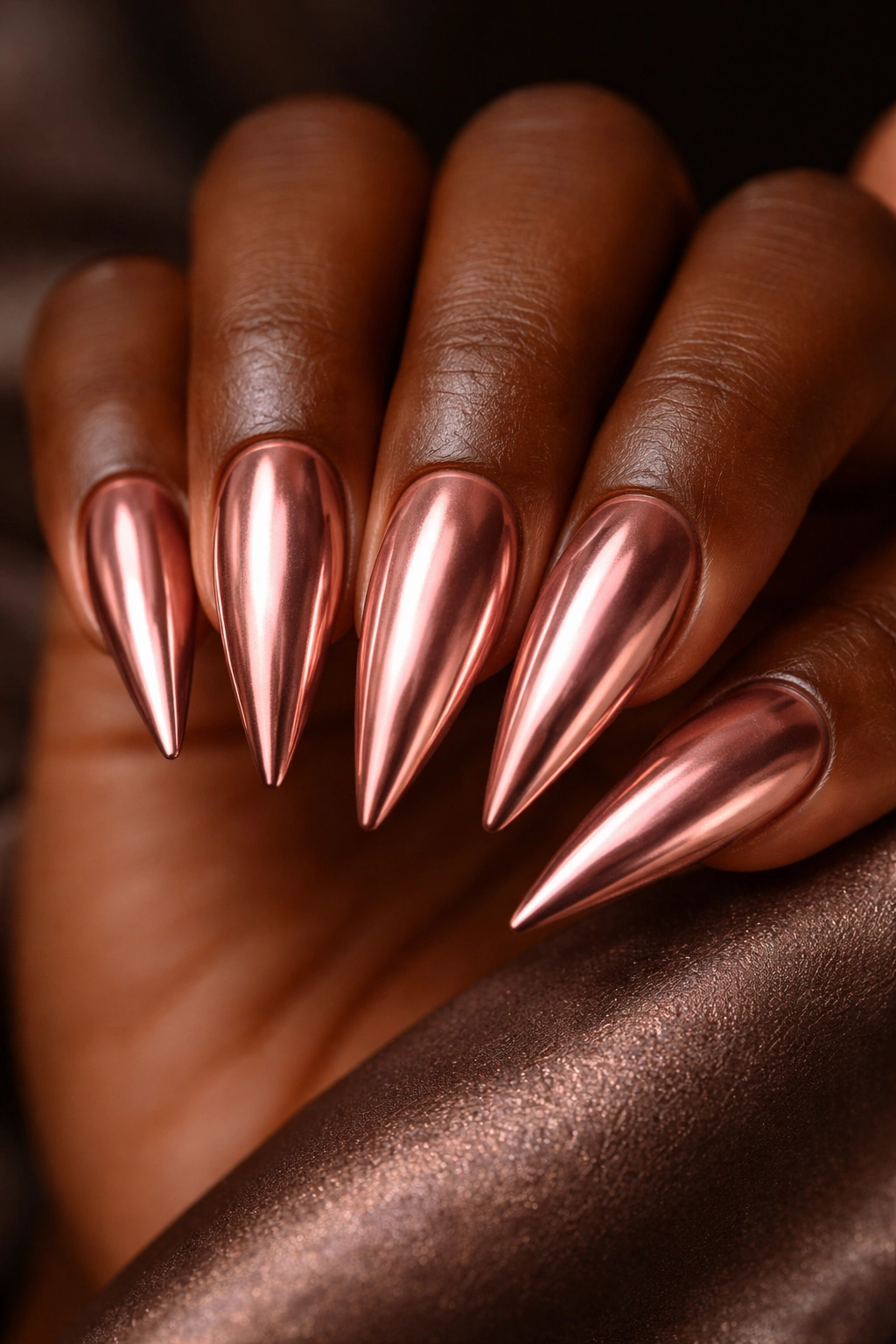 Rose gold metallic nails over caramel base on stiletto nails.