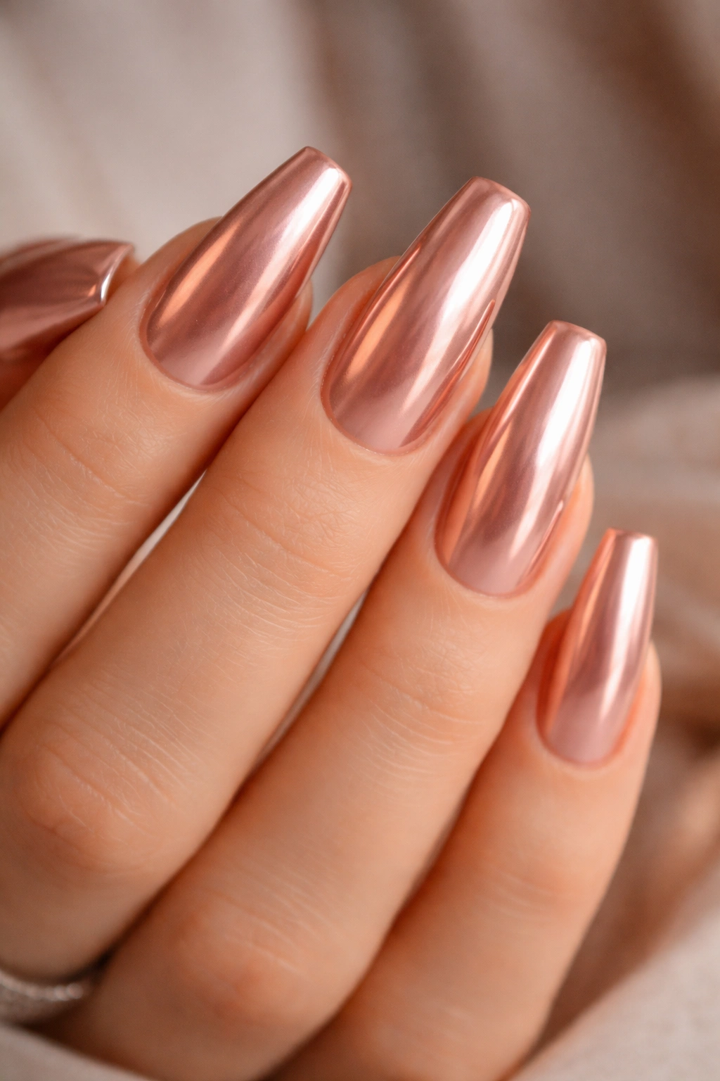 Rose gold chrome over nude base on nude-toned ballerina nails