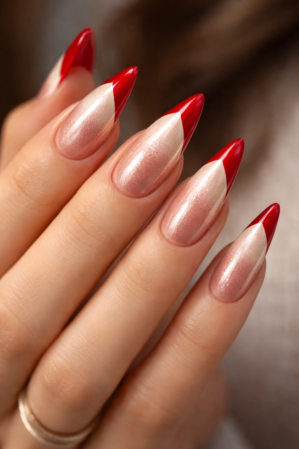 Close-up of rose gold base stiletto nails with champagne-tinted white tips