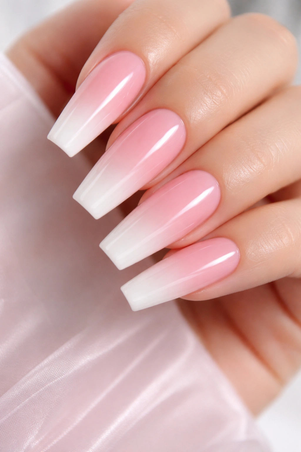 Close-up of rose pink ombre coffin nails with high-gloss finish