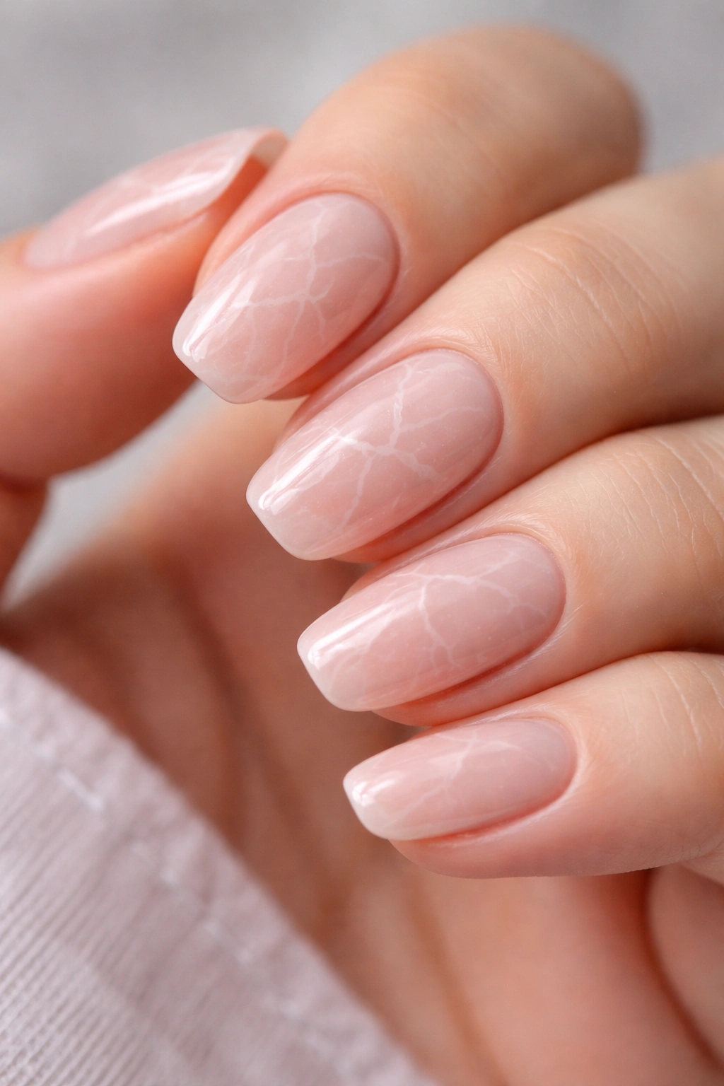 Close-up of rose quartz marble on a short nail with pink base and white veins