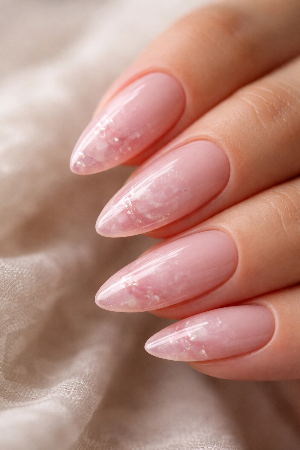 Close-up of almond nails with rose quartz dusty pink tips and subtle shimmer