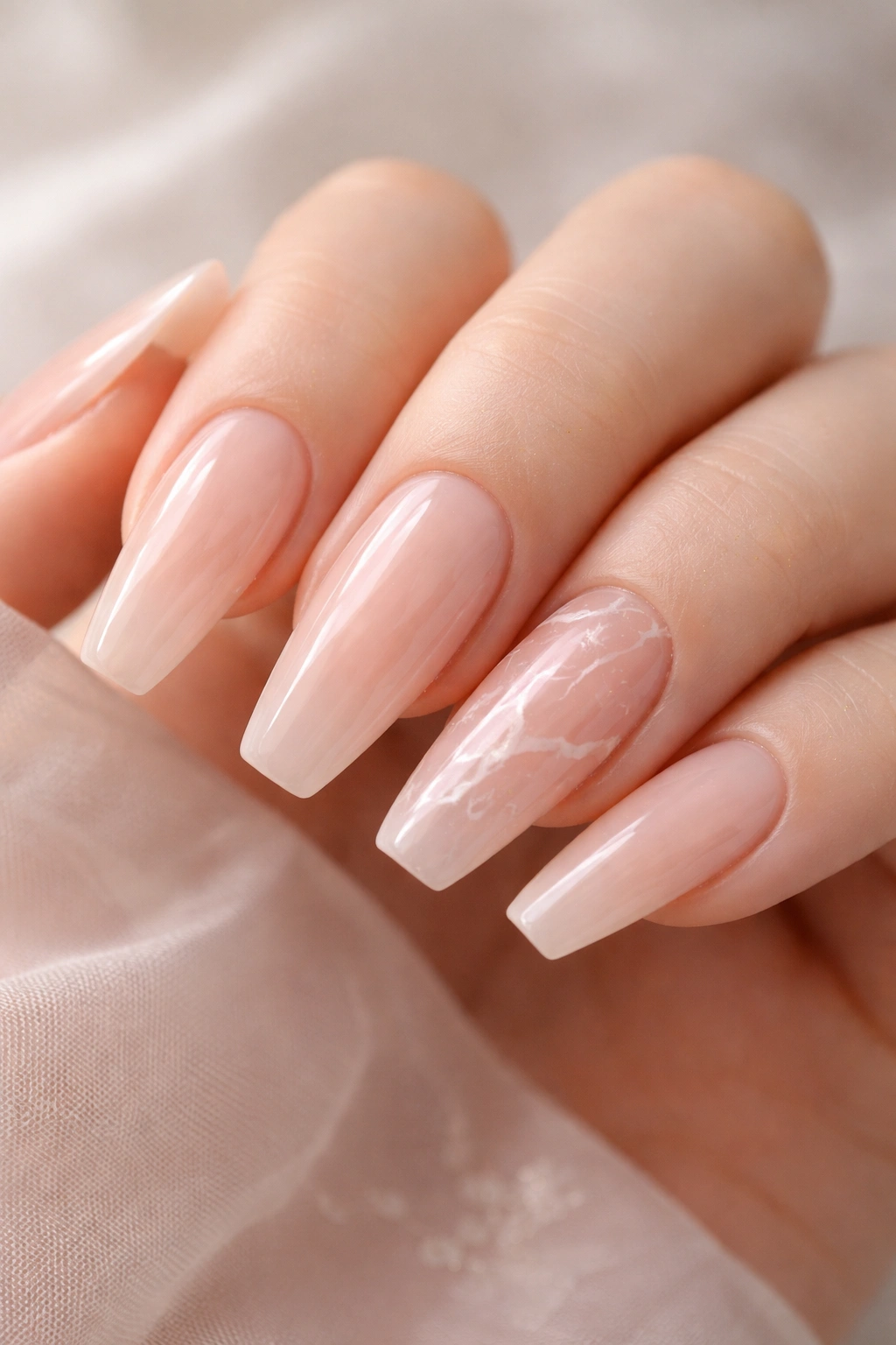 Rose quartz veil marble nails with subtle veining on a sheer base
