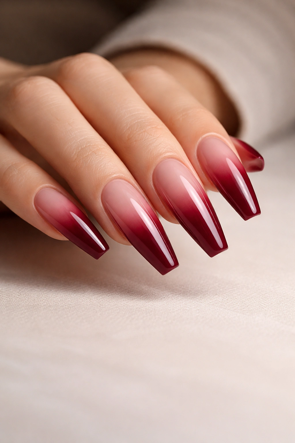 Close-up of deep rose wine French fade on long ballerina nails with a sheer pink remainder
