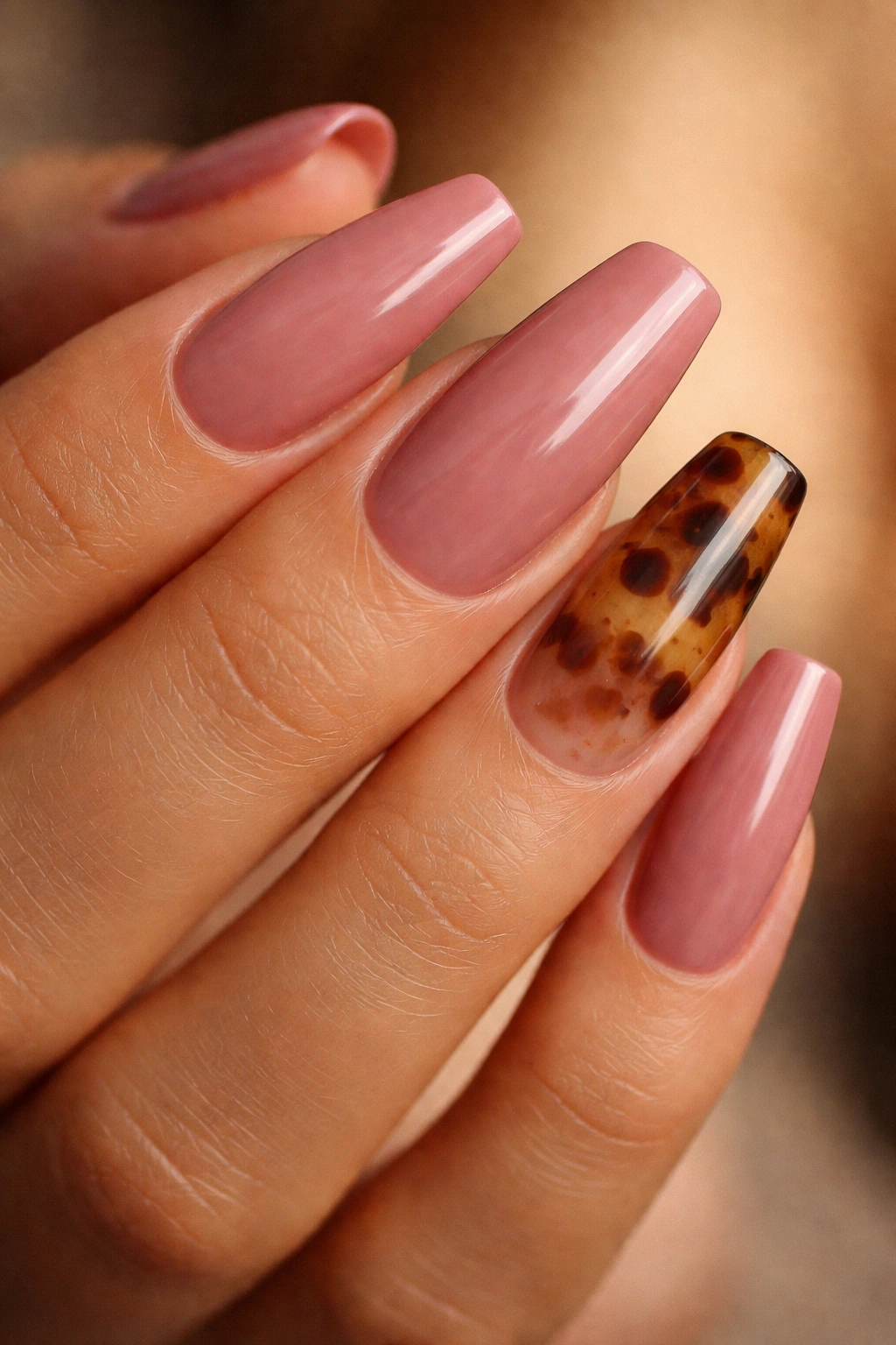 Close-up of Rosewood Blush nails with tortoiseshell accent on ring finger