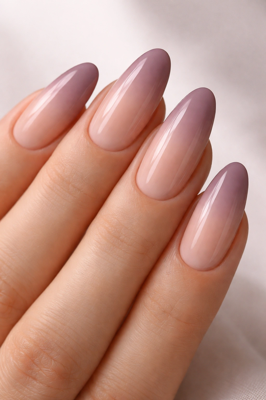Close-up of long oval nails with rosy nude to dusty mauve ombre