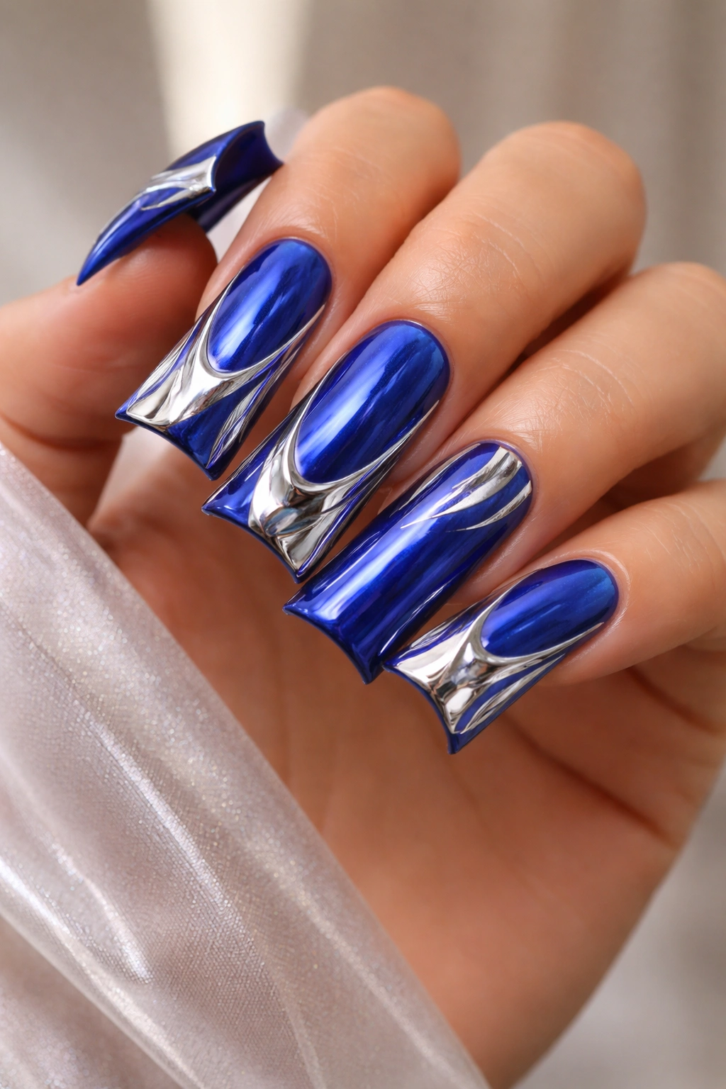 Close-up of royal blue duck nails with chrome mirror powder details
