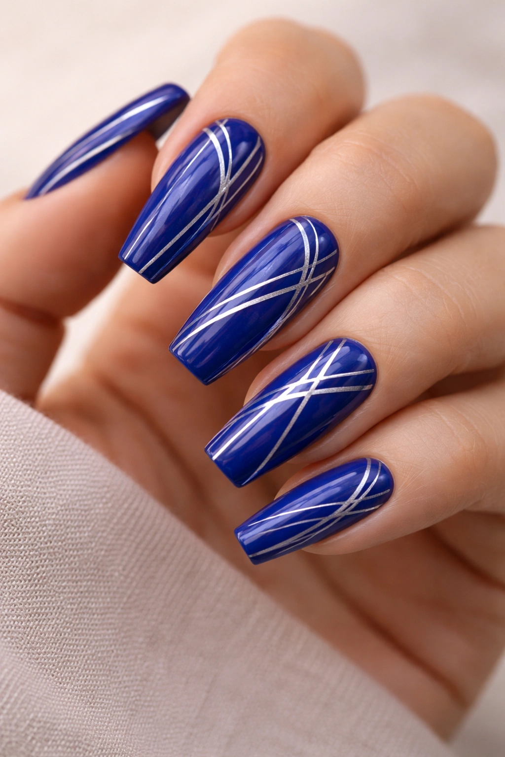 Close-up of royal blue nails with fine line artwork