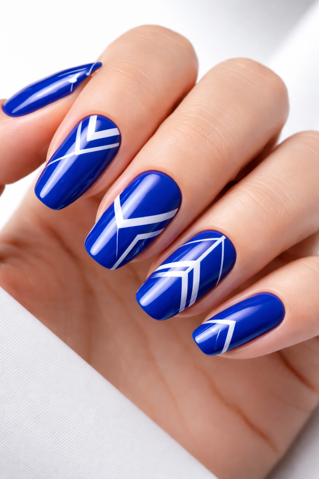 Royal blue nails with crisp white geometric patterns