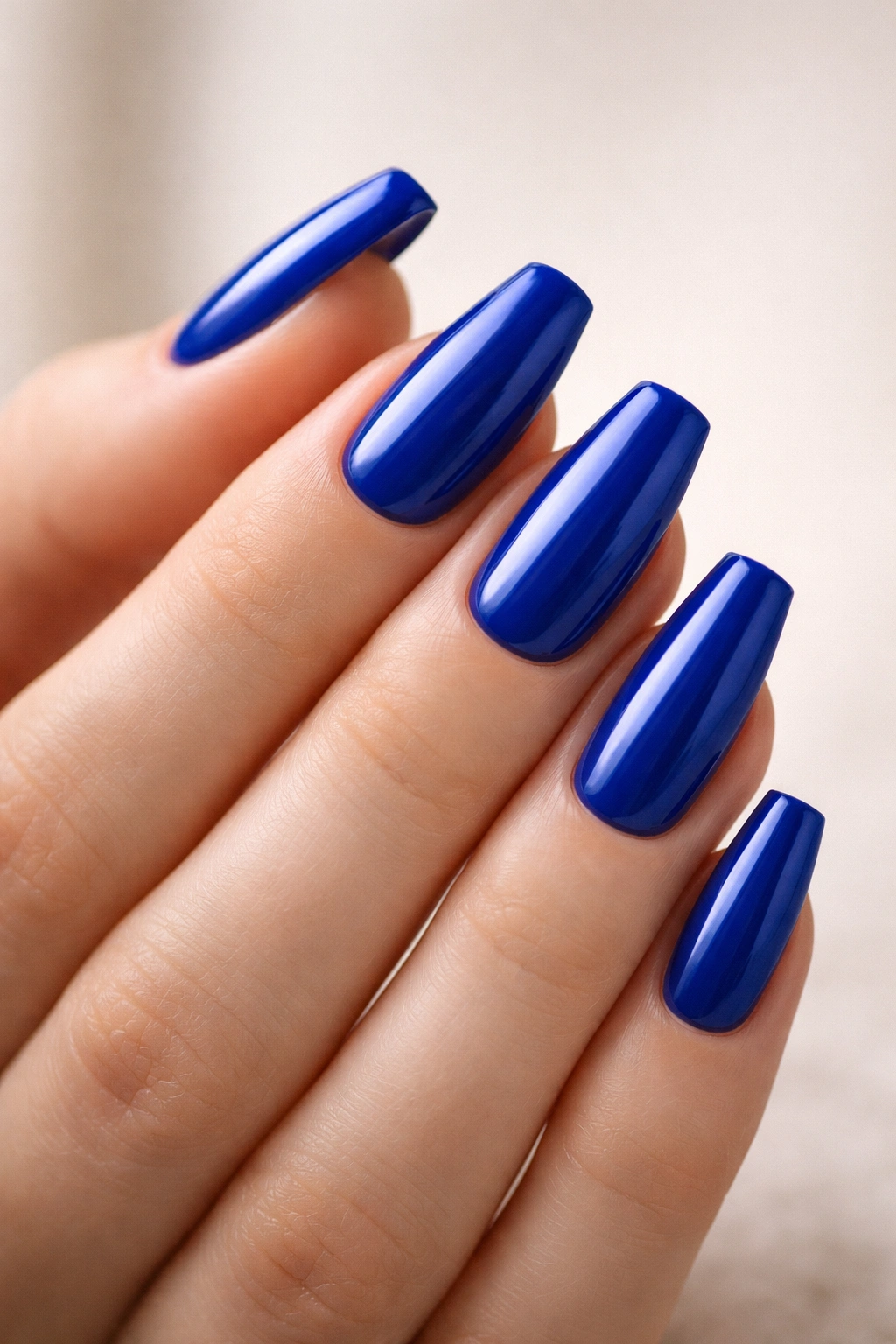 Close-up of medium coffin nails in glossy royal blue with no decoration