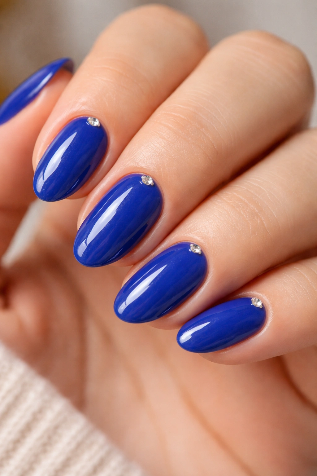 Close-up of royal blue nails with a tiny crystal at the cuticle