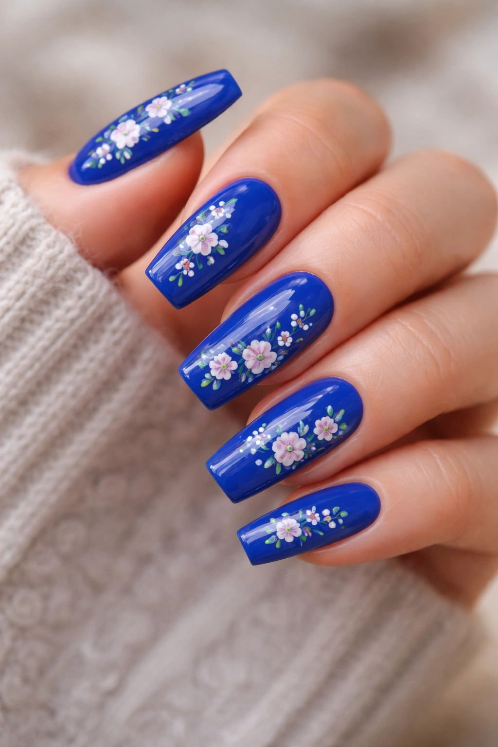 Medium coffin nails painted royal blue with tiny white and pale pink flowers