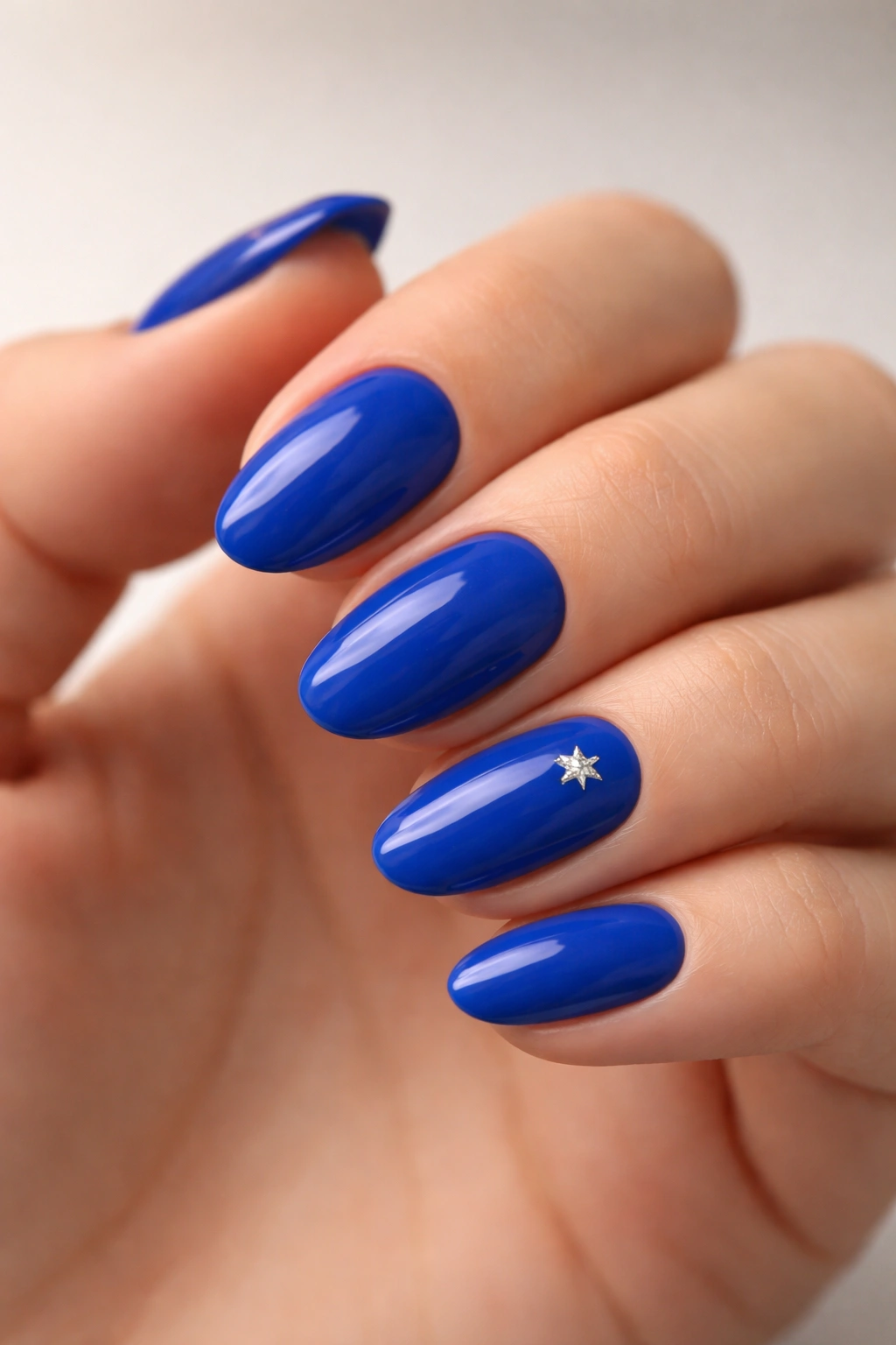 Royal blue nails with a single silver star accent on one nail
