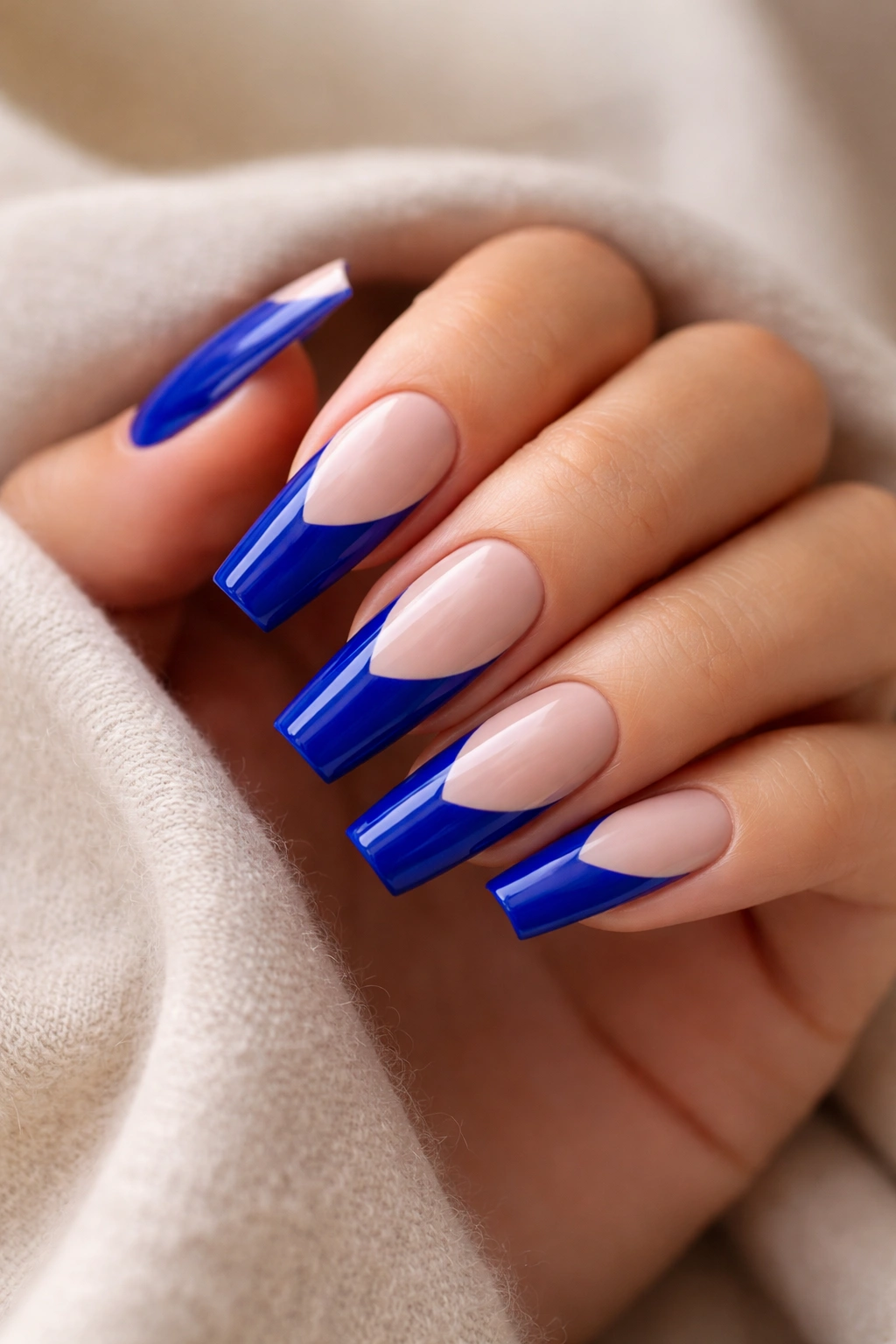 Close-up of royal blue nails with nude tip manicure
