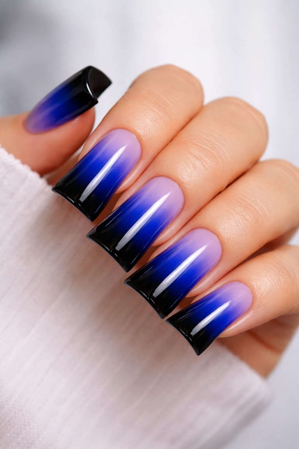 Close-up of royal blue to black ombre duck nails