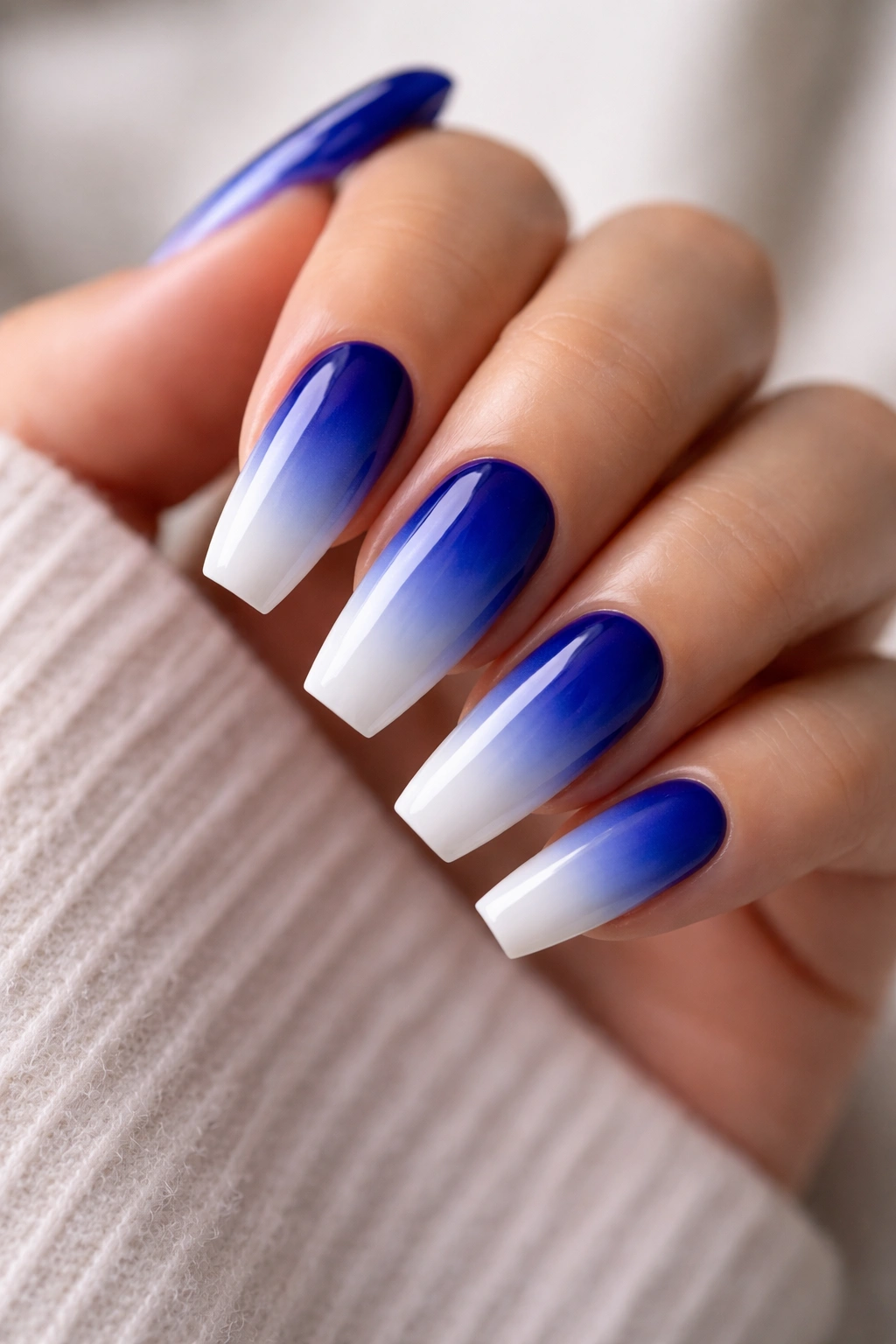 Ombre nails transitioning from royal blue to white on medium coffin nails