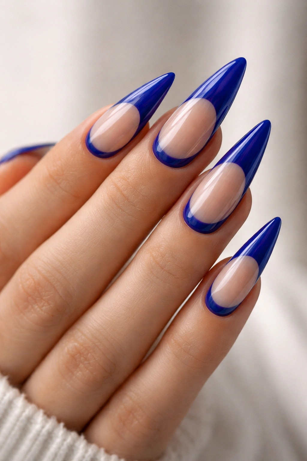 Close-up of reverse French royal blue stilettos nails