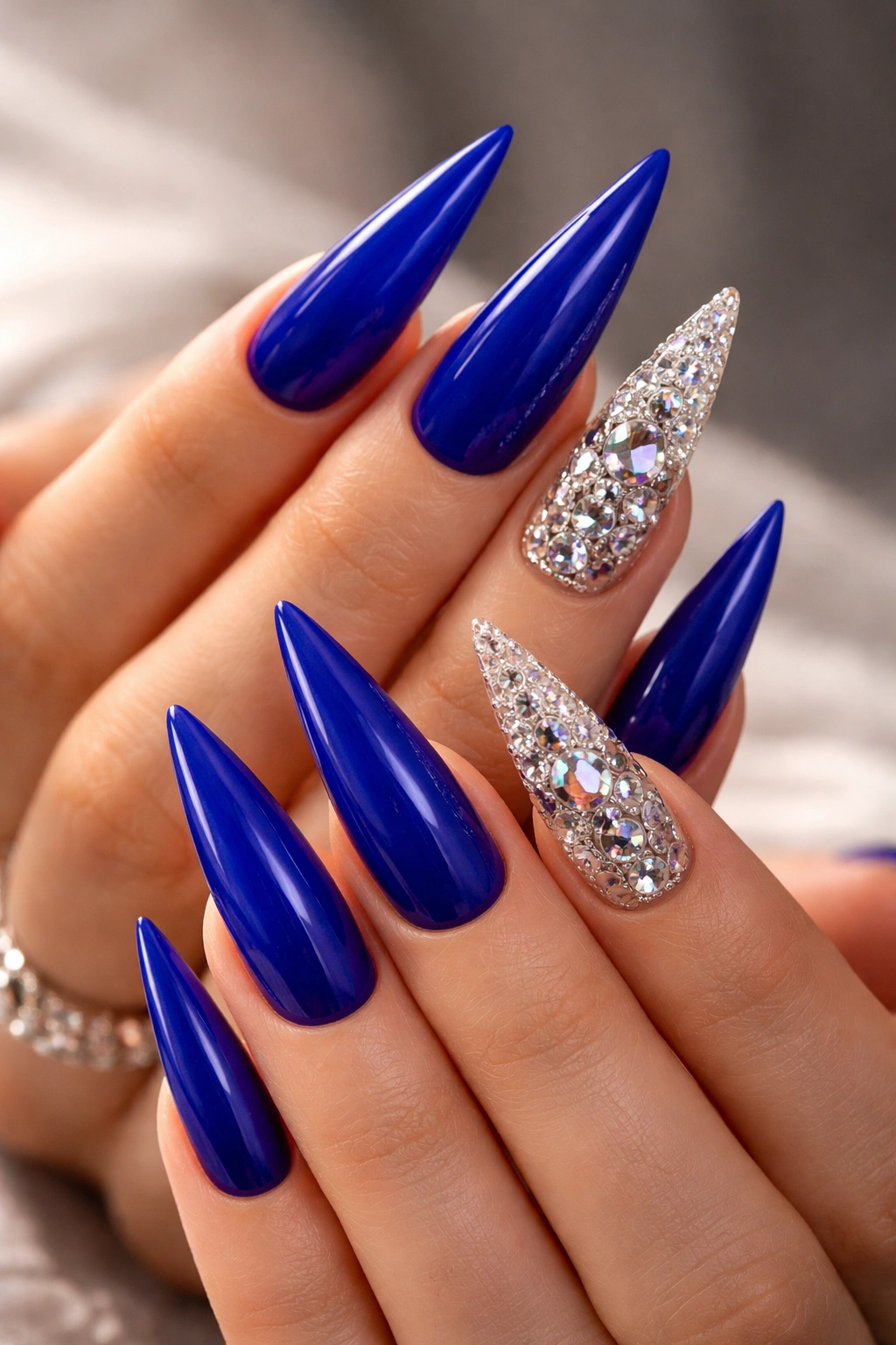 Royal blue stiletto nails with rhinestone accents on accent nails