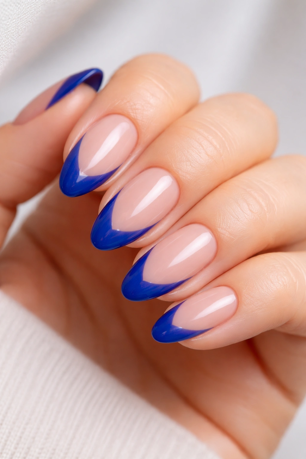 Short almond nails with diagonal royal blue side French and negative space