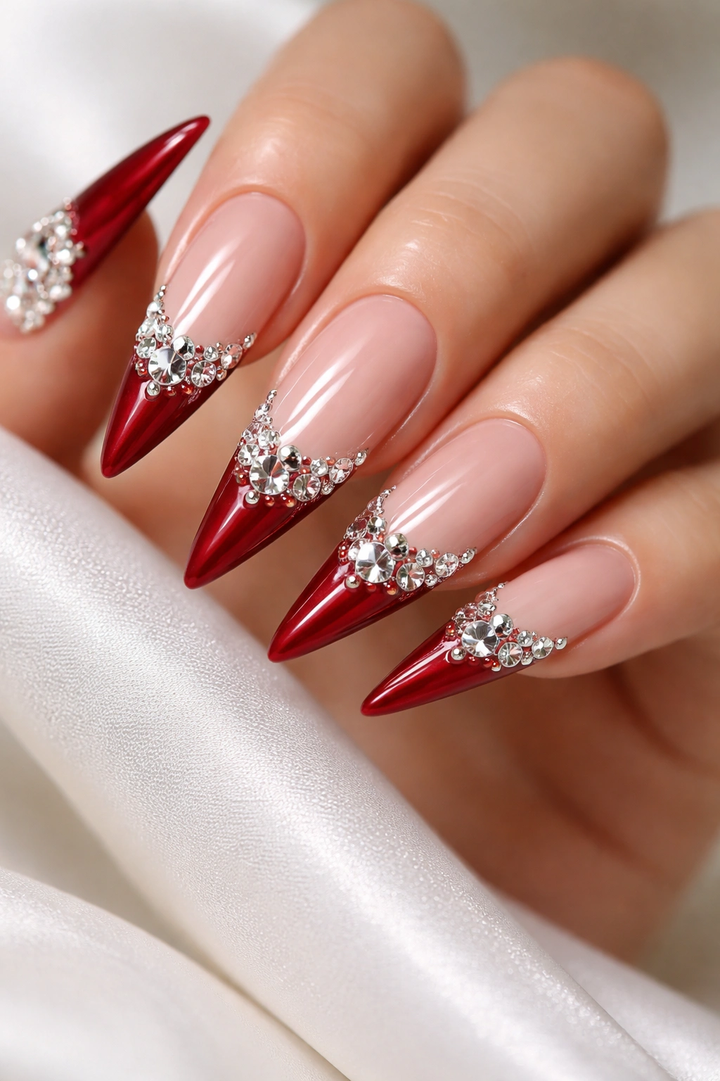 Close-up of red stiletto nails with diamond rhinestones on white tips