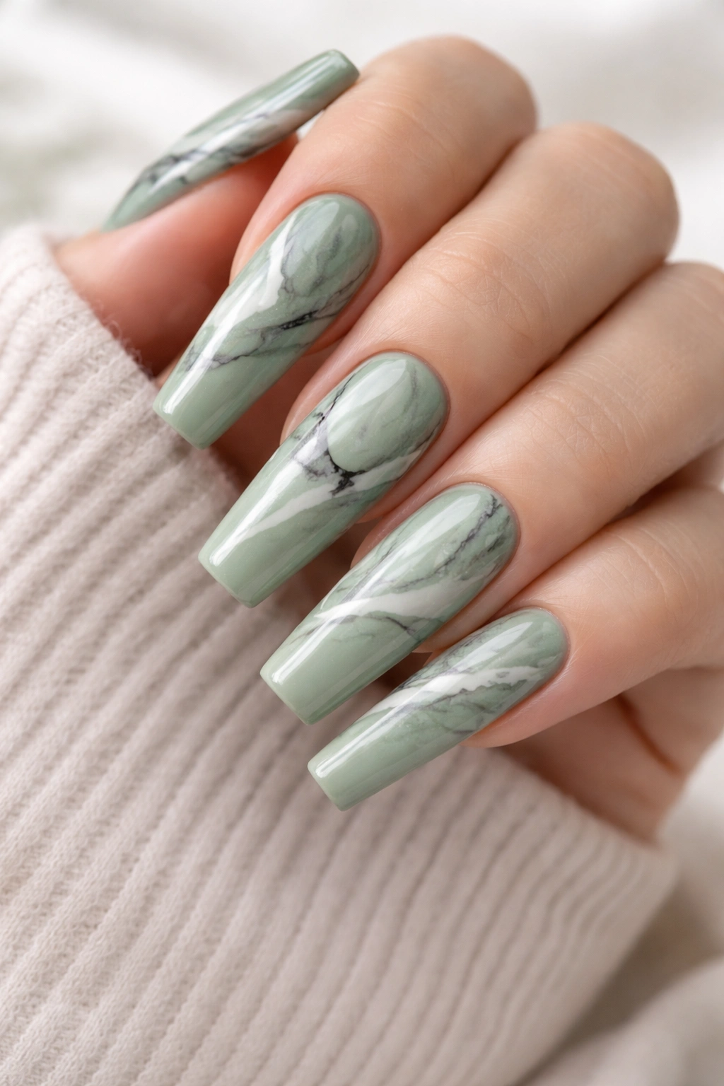Close-up of sage green nails with marble effect