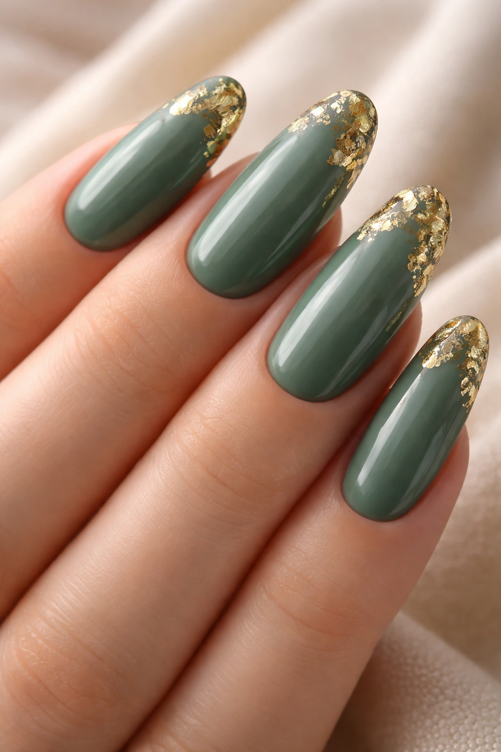 Long round nails in deep sage green with gold leaf accents