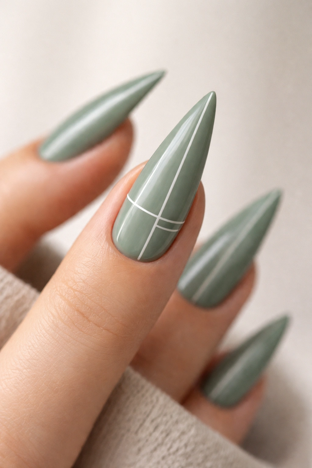 Sage green stiletto nail with white minimalist lines