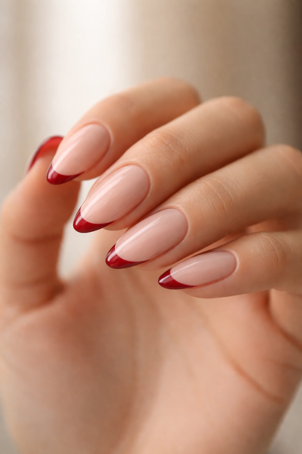 Almond nails with soft taper and thin red tip line on milky nude base