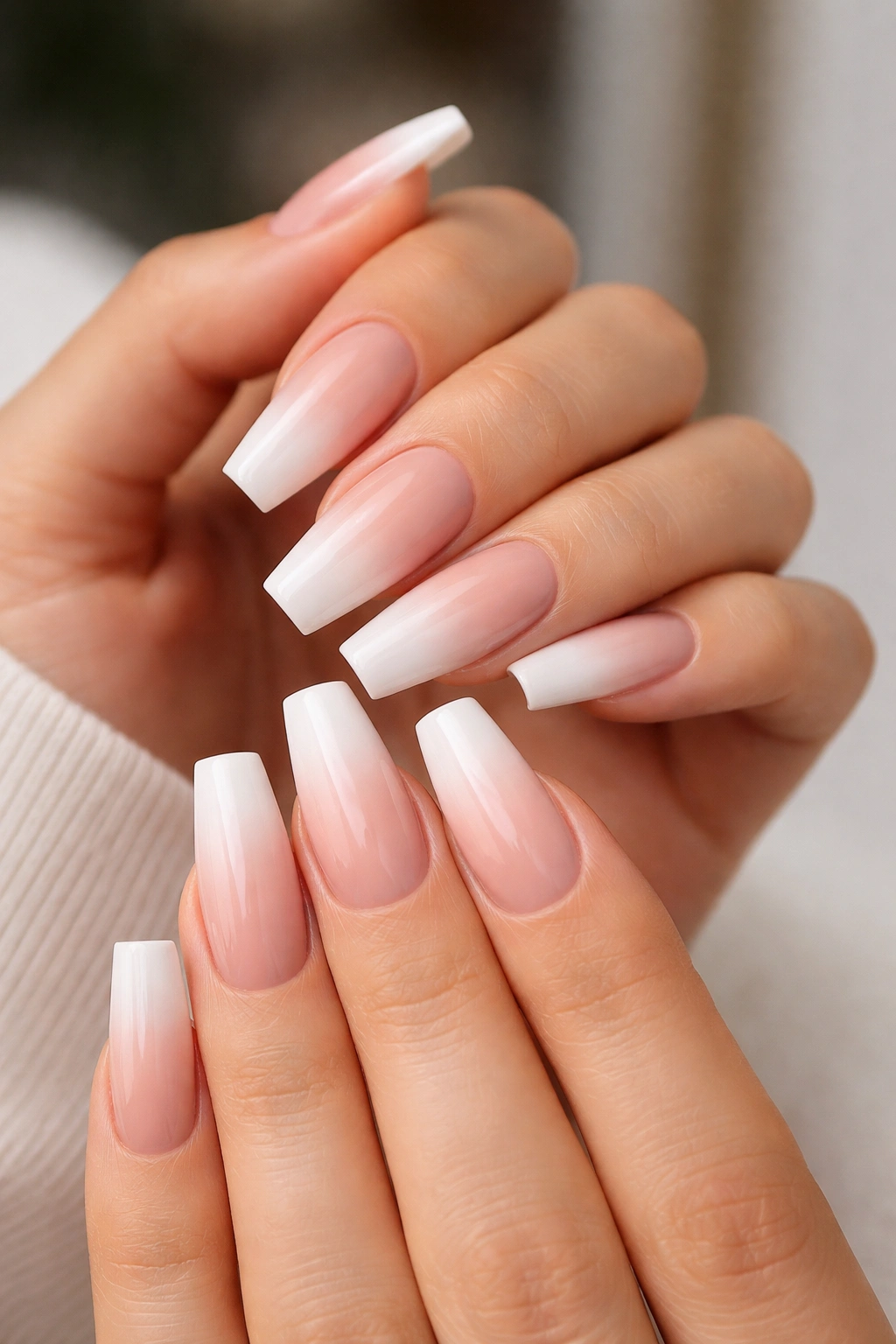 Hands with ombre ballerina nails showing sheer base and soft white tip