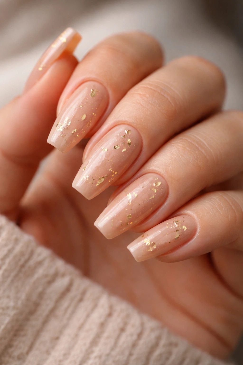 Sand nude nails with scattered gold leaf flecks on ballerina nails