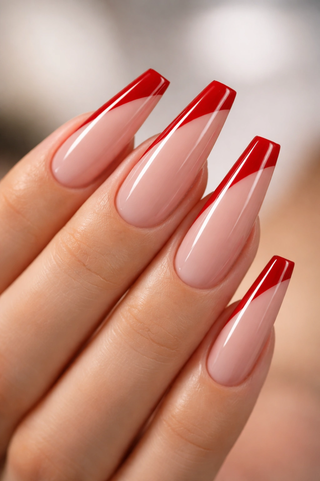 Close-up of scarlet side-swipe nails with diagonal red tip on nude base