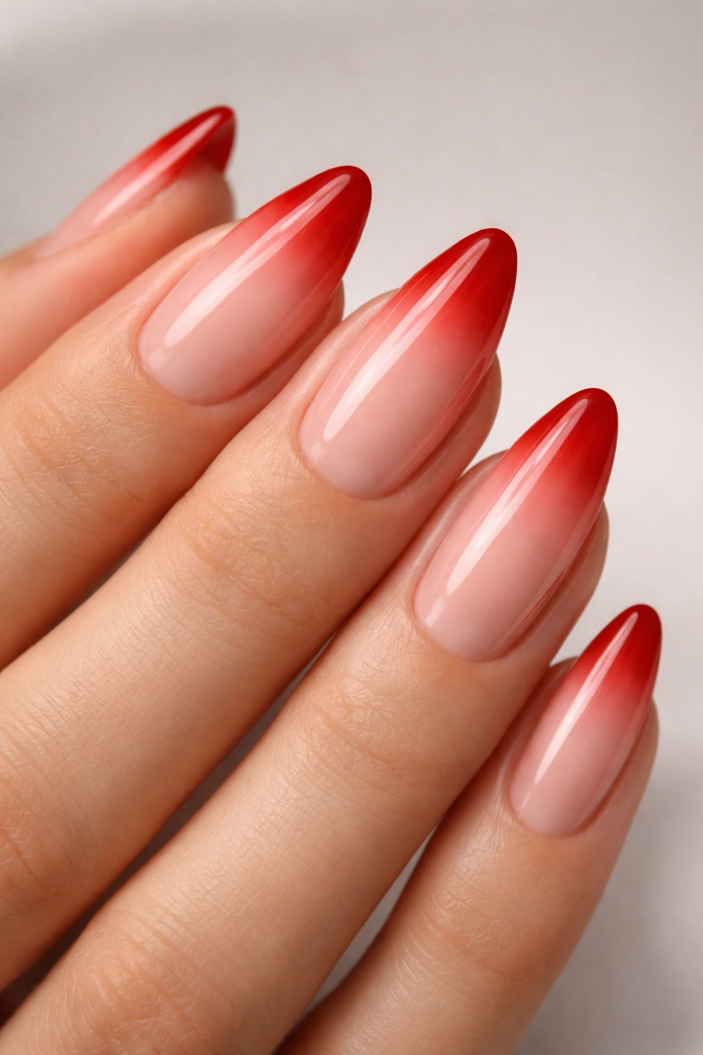 Almond nails with nude base and scarlet tip ombre