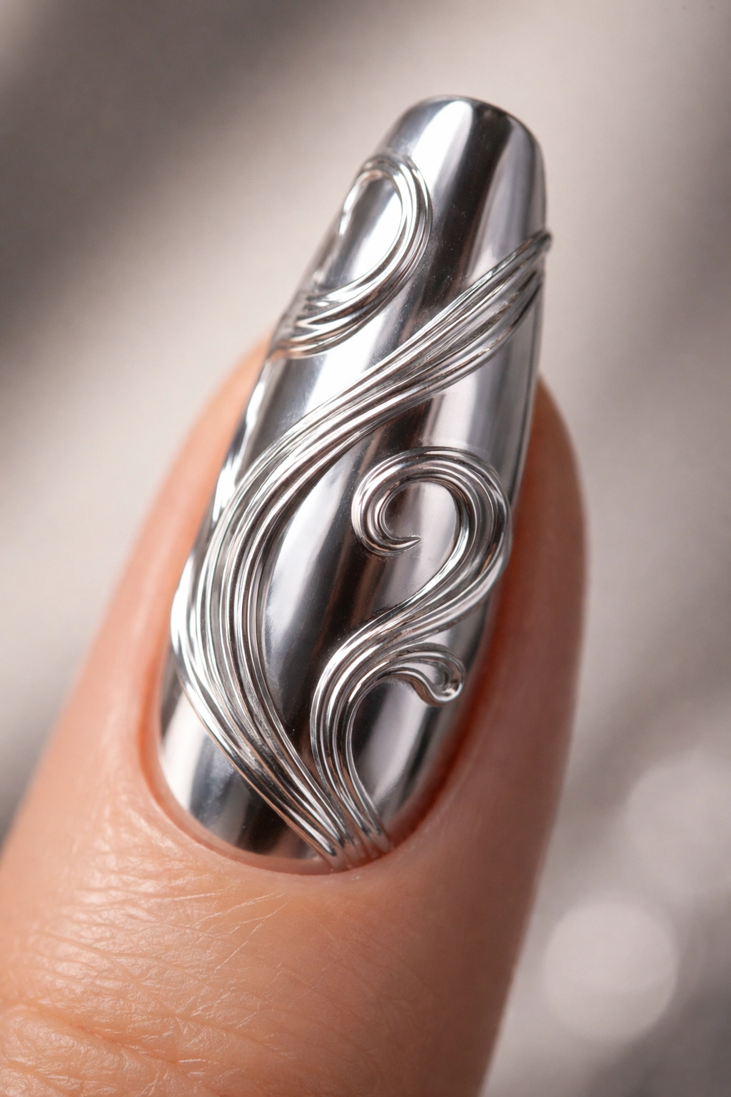 Close-up of 3D silver swirl nail art over chrome base