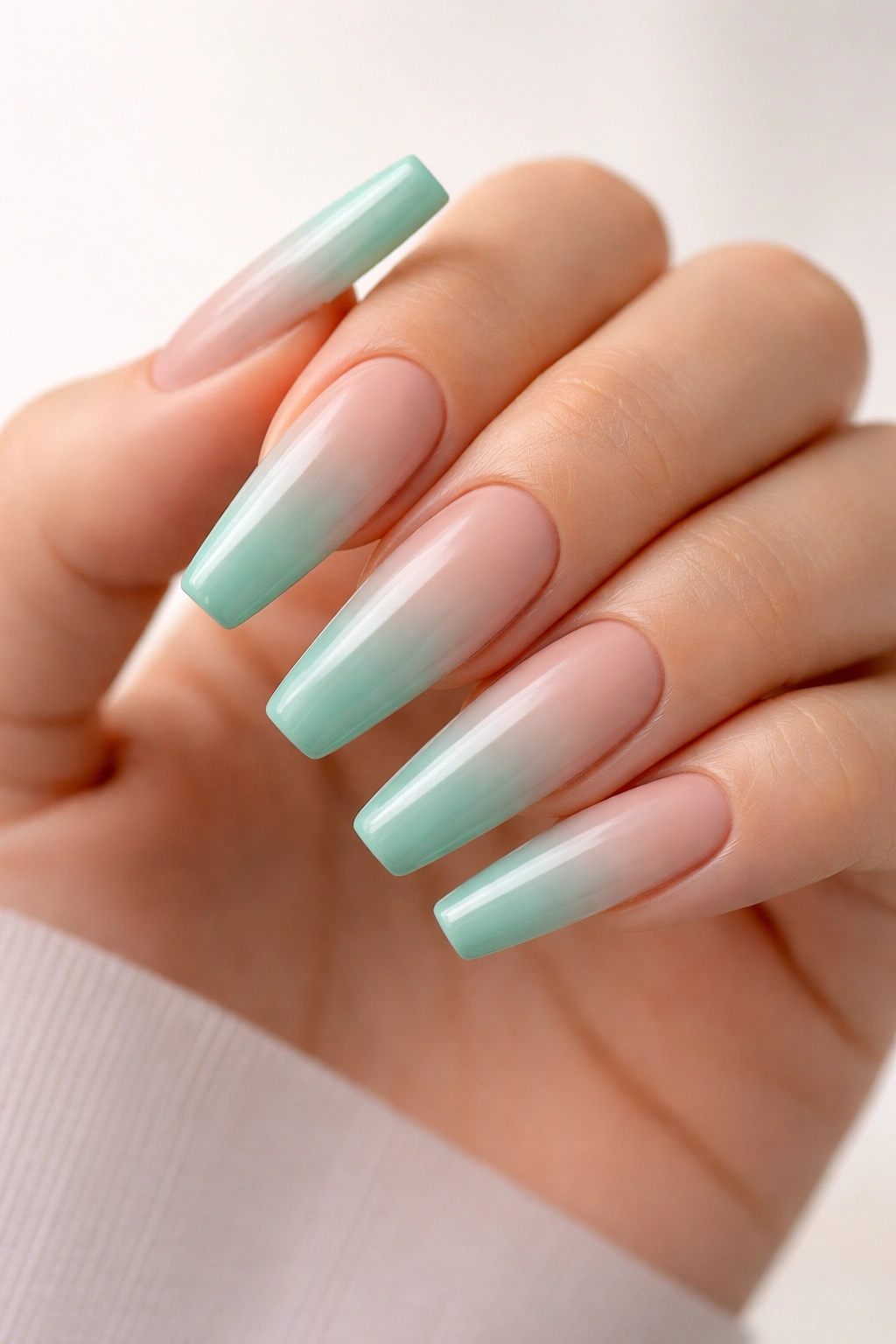 Close-up of seafoam to nude ombre on long coffin nails with glossy finish
