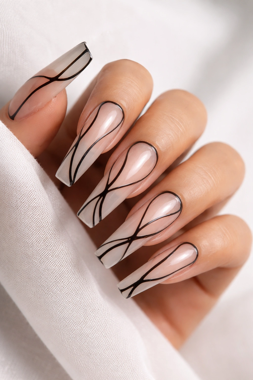 Coffin nails with sheer nude base and abstract black linework